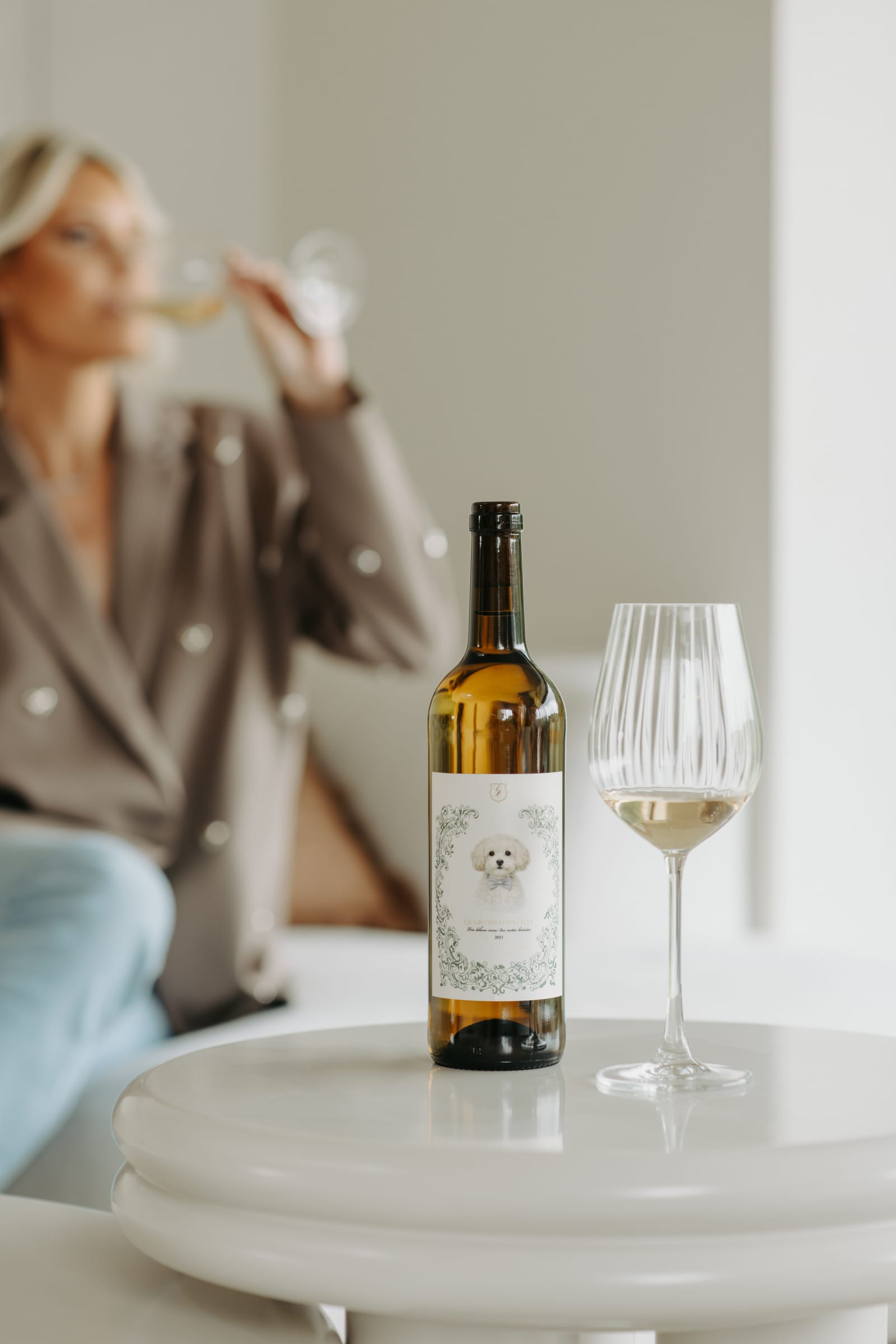 Le Grand Copychat — fles, glas en Amy aan een tafel